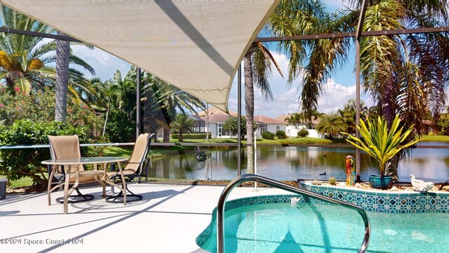 view of pool with a patio and a water view