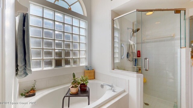 bathroom featuring shower with separate bathtub