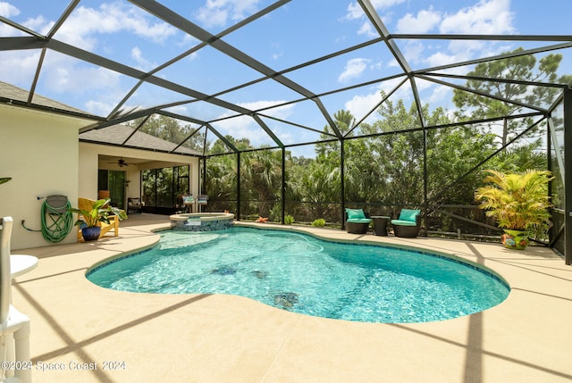 view of pool featuring an in ground hot tub, a patio area, glass enclosure, and ceiling fan