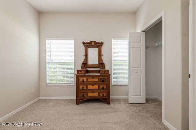 carpeted bedroom featuring a closet and multiple windows