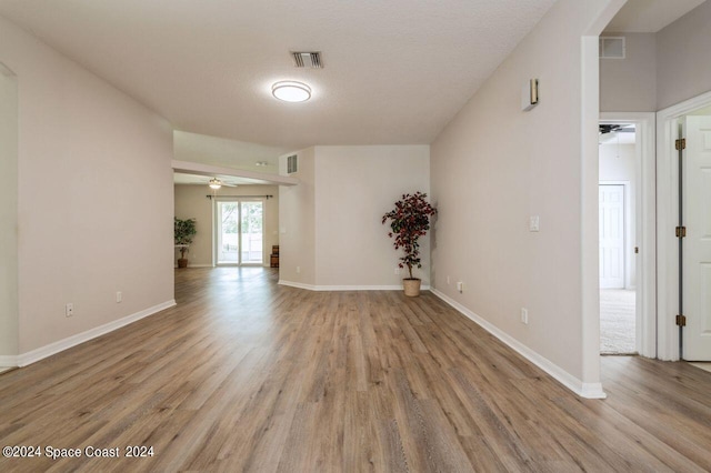 empty room featuring ceiling fan, a textured ceiling, and light wood-type flooring