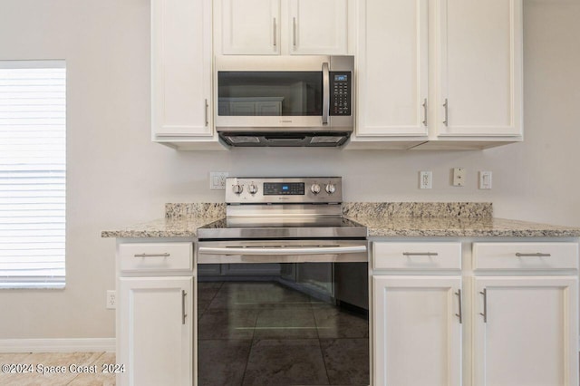 kitchen with white cabinets, light tile patterned floors, stainless steel appliances, and a healthy amount of sunlight