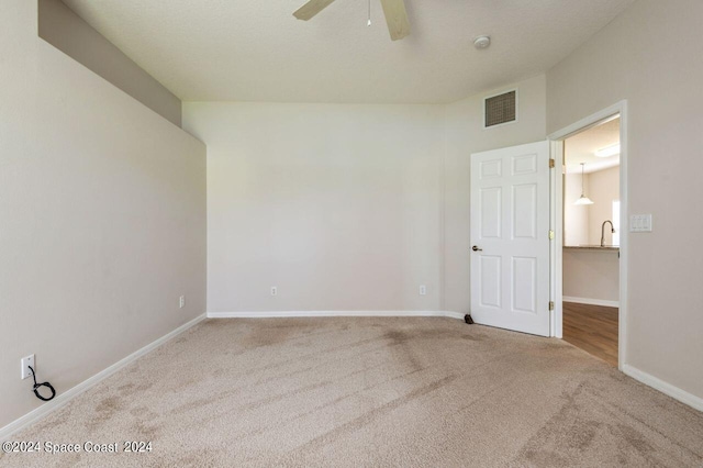 carpeted empty room with ceiling fan and sink