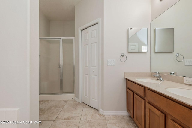 bathroom with tile patterned flooring, vanity, and walk in shower