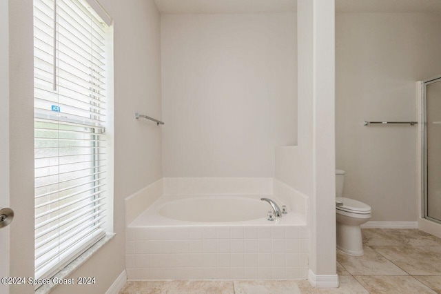 bathroom featuring tile patterned flooring, shower with separate bathtub, and toilet