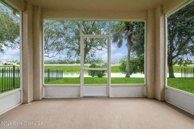 unfurnished sunroom with a water view