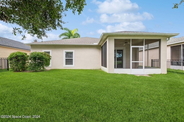 back of property with a sunroom and a yard