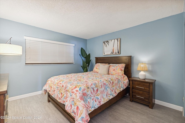 bedroom with hardwood / wood-style floors and a textured ceiling