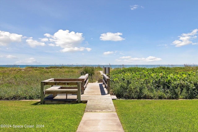 view of property's community with a yard and a water view