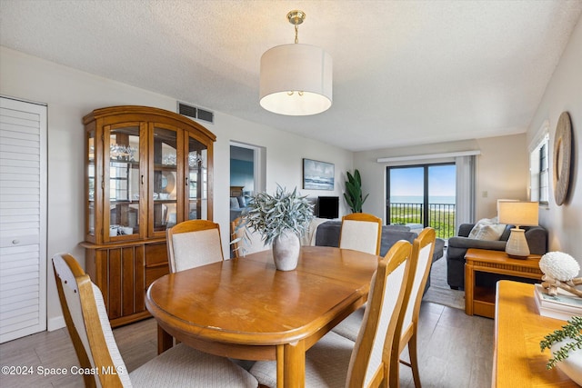 dining area featuring a textured ceiling and hardwood / wood-style flooring