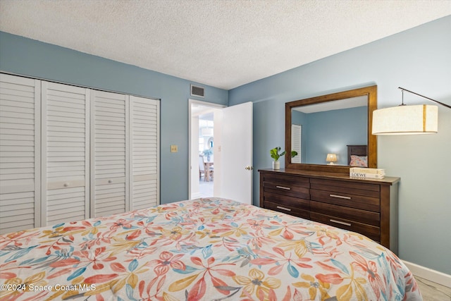 bedroom with a textured ceiling and a closet