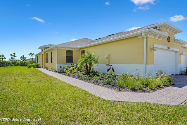 ranch-style home with a garage and a front lawn