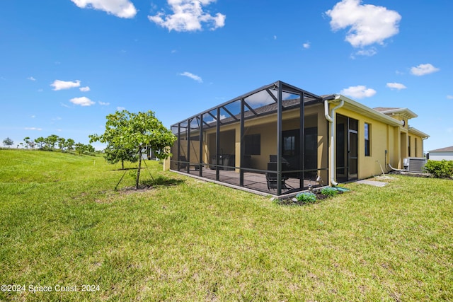 rear view of house featuring a lawn, a patio, a lanai, cooling unit, and stucco siding