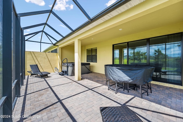 view of patio / terrace with glass enclosure and a hot tub