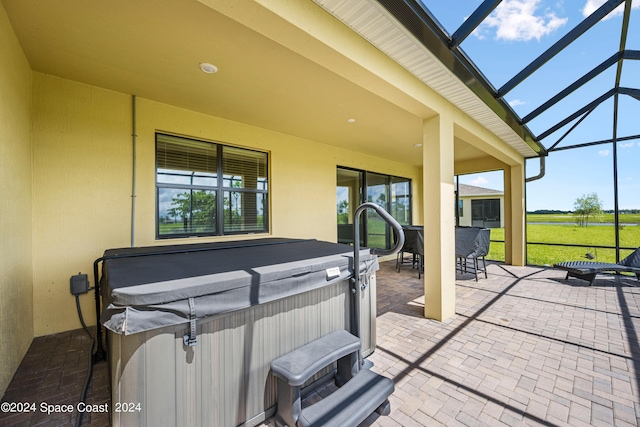 view of patio with outdoor dining area, a lanai, and a hot tub