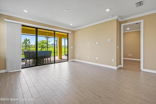 empty room with baseboards, ornamental molding, visible vents, and light wood-style floors