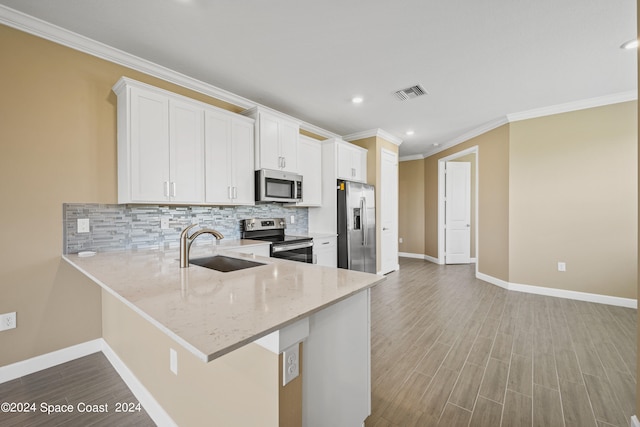 kitchen with stainless steel appliances, sink, white cabinetry, and light hardwood / wood-style floors