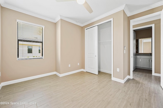 unfurnished bedroom featuring light wood finished floors, baseboards, ceiling fan, ornamental molding, and a closet