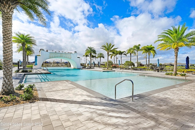 pool with a patio area and a water slide