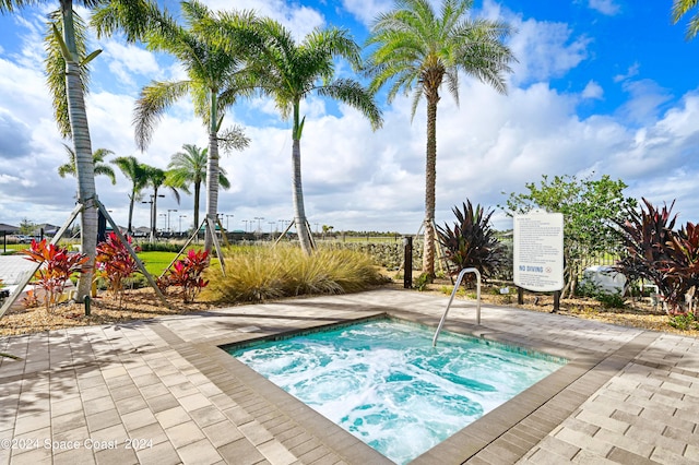 view of pool with a hot tub