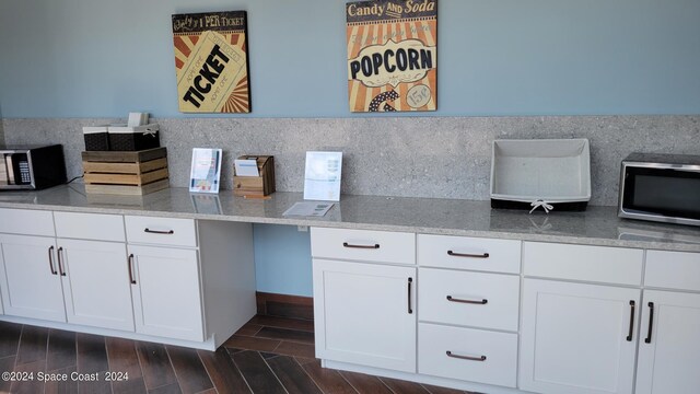 kitchen featuring stone countertops, dark hardwood / wood-style flooring, backsplash, and white cabinets