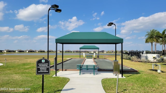 view of property's community with a lawn and fence