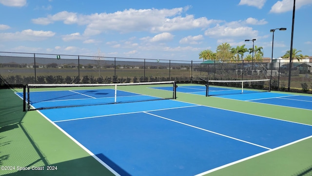 view of tennis court with community basketball court and fence