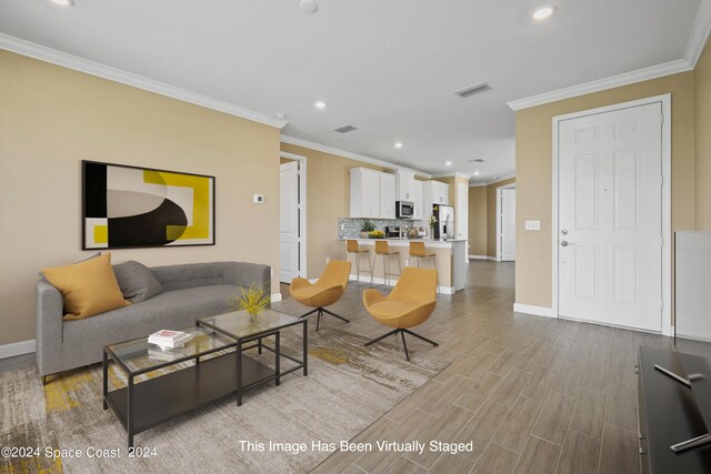 living room with light wood-type flooring and crown molding