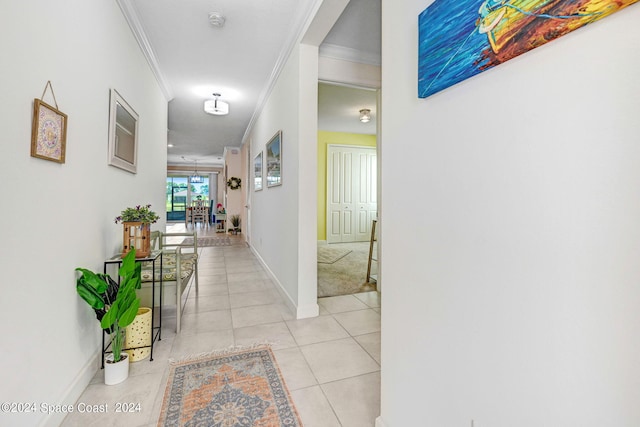 corridor with light tile patterned floors and crown molding