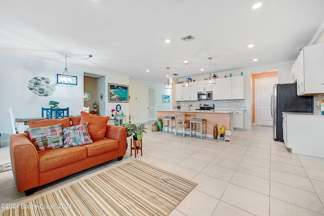 living area featuring light tile patterned floors, visible vents, and ornamental molding