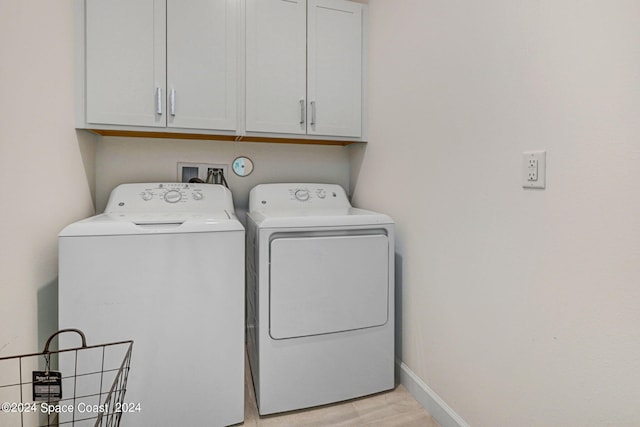 washroom with washer and clothes dryer and cabinets