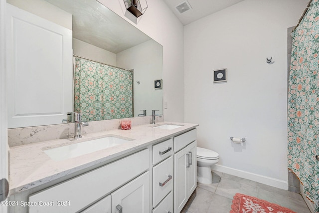 bathroom with double vanity, visible vents, toilet, and a sink