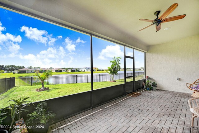 unfurnished sunroom featuring ceiling fan