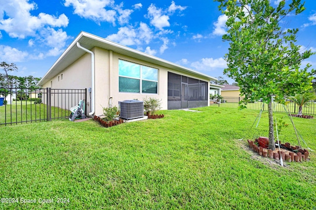 back of property featuring a lawn, cooling unit, a fenced backyard, and stucco siding