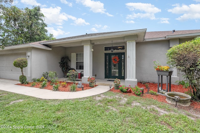 view of front of home with a garage, a front lawn, and covered porch