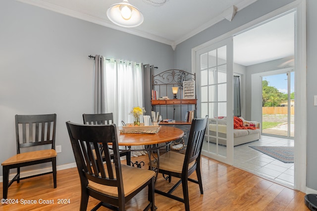 dining area with crown molding and light hardwood / wood-style floors