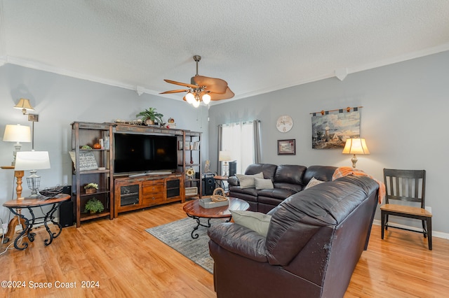 living room featuring wood-type flooring, a textured ceiling, ornamental molding, and ceiling fan