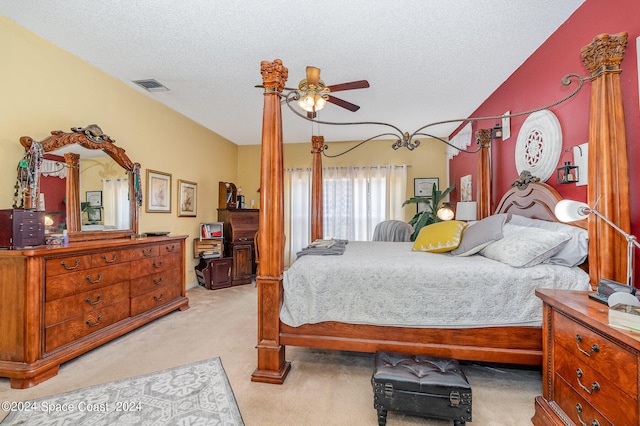 bedroom with a textured ceiling, ceiling fan, and light carpet