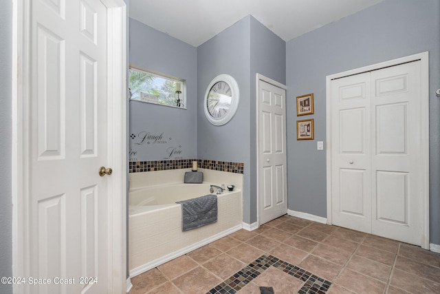 bathroom with tile patterned flooring and tiled tub