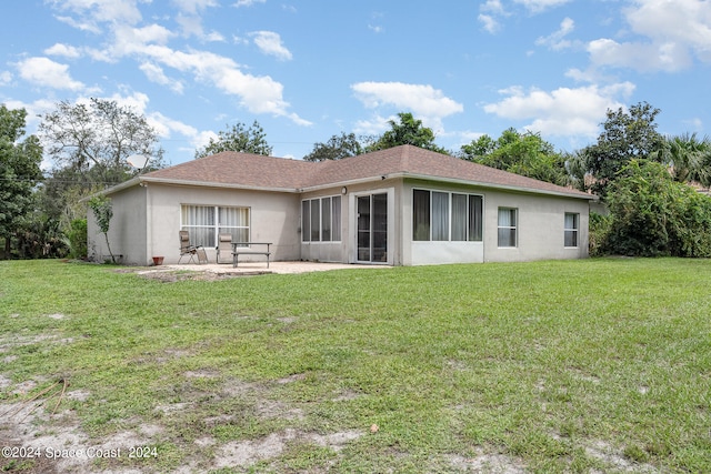 rear view of house featuring a yard and a patio area