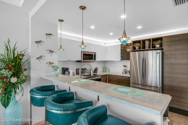 kitchen with light countertops, open shelves, stainless steel appliances, backsplash, and a peninsula