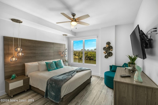 bedroom with baseboards, light wood-type flooring, and ceiling fan