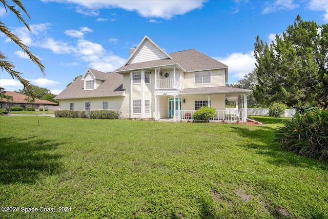 view of front of property with a balcony and a front yard