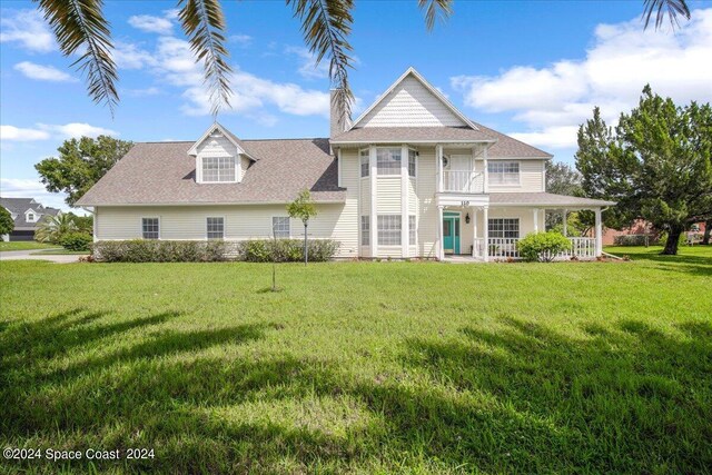 view of front of home with a balcony and a front yard