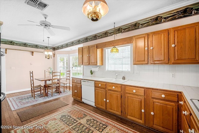 kitchen featuring hanging light fixtures, dishwasher, ceiling fan with notable chandelier, sink, and wood-type flooring