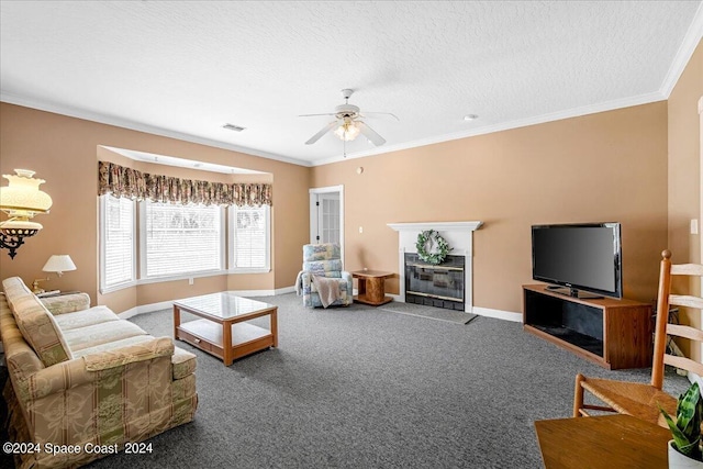 living room featuring carpet flooring, ceiling fan, a tile fireplace, and crown molding