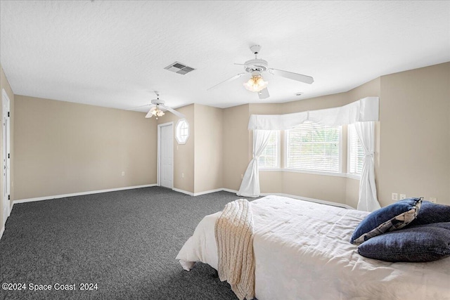 carpeted bedroom with ceiling fan and a textured ceiling