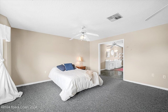 bedroom featuring a textured ceiling, dark carpet, ceiling fan, and ensuite bathroom