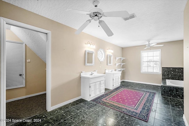 bathroom with a tub to relax in, vanity, a textured ceiling, and ceiling fan