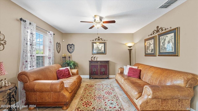 tiled living room with ceiling fan and a textured ceiling